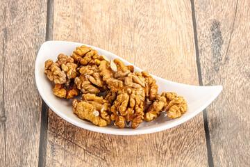 Cracked unshelled walnut in the bowl
