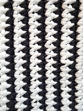 Vertical black and white lines background - handmade crocheted texture to illustrate the concept of contrast, black and white streaks in life, equilibrium of equality and diversity