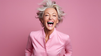 Portrait of mature woman celebrating on pink background