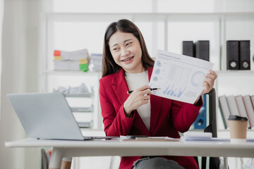 Businesswoman using laptop and calculator to do finance, mathematics on table in office and business background, tax, accounting, statistics and analytical research concept.