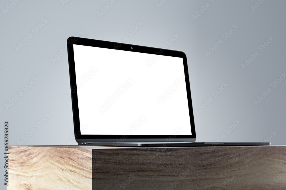 Poster close up of empty white laptop monitor on wooden surface and gray wall background. product presentat