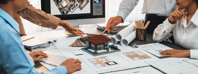 Group of interior architect designer discussing together on blueprint and laptop screen display...