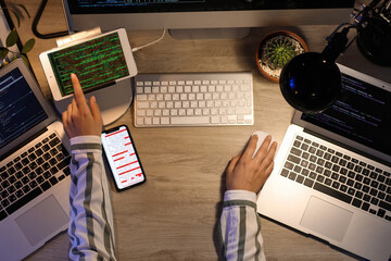 Female programmer working in office at night, top view