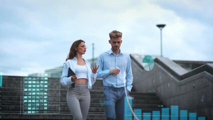 Two young business partners walk down stairs past digitally superimposed graphs, tables, financial data and work-relevant statistics - Powered by Adobe