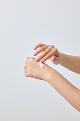 A gesture as if a woman is applying white cosmetics to the back of her hand.