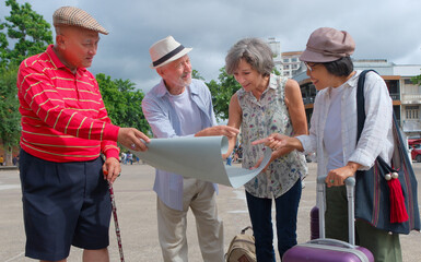 Group of seniors enjoy visiting Chiang Mai's old town with rough map. Elder group travel happily with map tor discover old town. Vacation and travel concept.