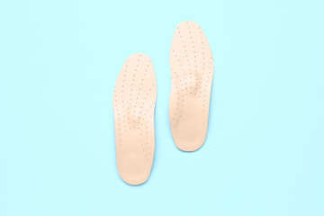 Leather orthopedic insoles on color background
