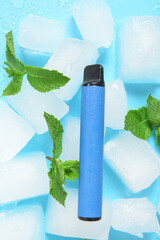 Electronic cigarette with mint and ice cubes on blue background