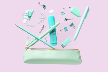 Flying pencil case and school stationery on purple background