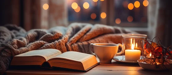 Foto op Canvas Hygge ambiance at home assortment of cookies vintage books glasses hot drink candle and fairy lights © Vusal