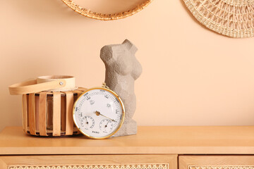 Aneroid barometer and decor on table in room, closeup