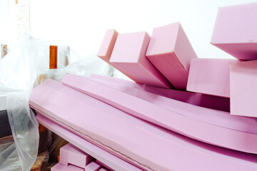Stacked sheets of pink foam rubber in furniture production workshop