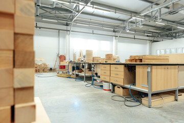 Stacked wooden bars in workshop of furniture manufacture