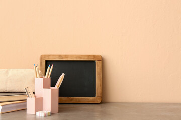 Chalkboard and holder with different stationery on desk