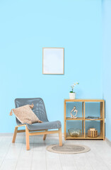 Comfortable armchair and shelving unit with decor near color wall