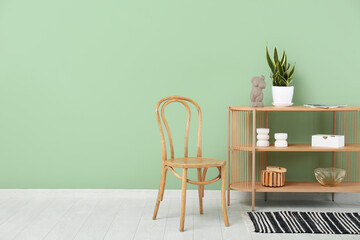 Wooden chair and shelving unit with decor near color wall