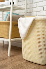 Beige plastic basket for laundry in a room