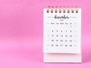 The December 2023 desk calendar for 2023 year on pink color background.