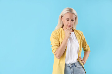 Thoughtful mature woman on blue background