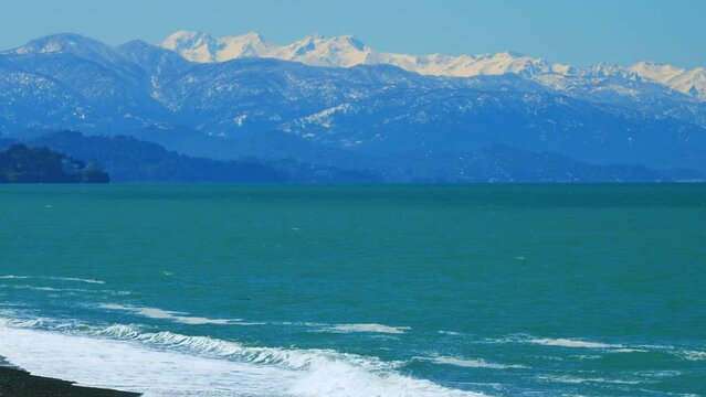 Snowcapped Mountain. Mountain Range Covered In Snow With Calm Sea. Still.