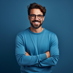 Young handsome man with beard wearing casual sweater and glasses over blue background, ai technology