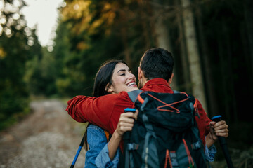 Hikers hugging with gear trekking through scenic wilderness