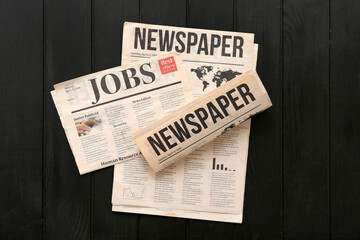 Morning newspapers on black wooden background