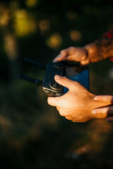 A male operating a drone and holding a joystick. Close up on hands
