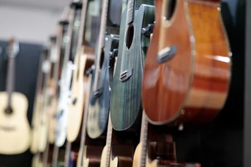 Poster acoustic guitars hanging on a wall in music store