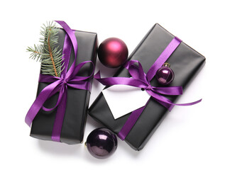 Black gift boxes with Christmas tree branch and balls on white background
