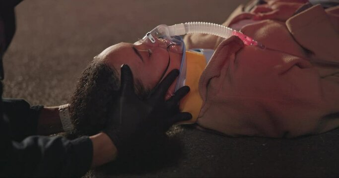 Accident, patient and neck brace in emergency, night and paramedic for medical service. Victim face, closeup and saving or rescue from disaster, first aid and ems and oxygen mask for drunk driving