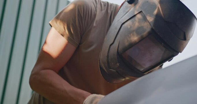Unprofessional car repair. A man repairs a car in an artisanal way.