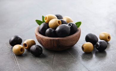 Olives on wooden plate onconcrete backgrounds.