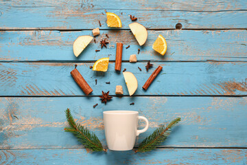 Ingredients for preparing tasty mulled wine and cup on blue wooden background