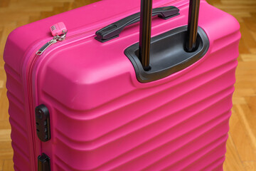 Zbliżenie na różową walizkę na kółkach spakowaną na podróż  - obrazy, fototapety, plakaty
