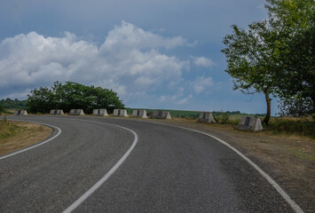 Highway making a turn, blue sky with clouds, beautiful landscape