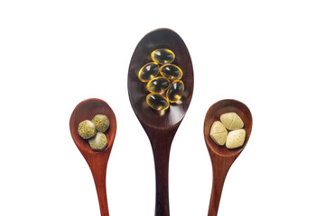 Top view variety of vitamins, minerals, and fish oil in pill form on a wooden spoon isolated on white or transparent cutout background. Dietary food supplements are a new alternative to health care.