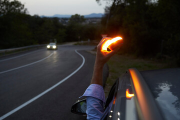Baliza V16 luminosa y conectada, colocada en el vehículo durante una avería en carretera - obrazy, fototapety, plakaty