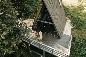 A woman rests and meditates in a house in the forest. Retreat and meditation concept