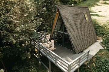 A woman rests and meditates in a house in the forest. Retreat and meditation concept