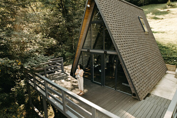 A woman rests and meditates in a house in the forest. Retreat and meditation concept