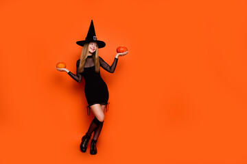 Full size portrait of cheerful evil sorcerer girl hands hold pumpkin empty space ad isolated on...