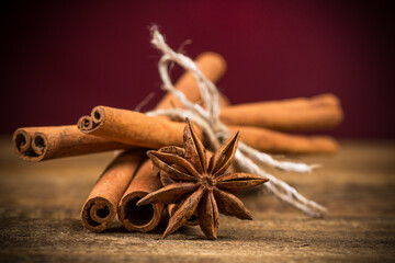 Close up of cinnamon sticks and star anise on wood - 659824023