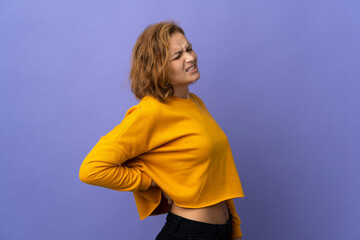 Young Georgian woman isolated on purple background suffering from backache for having made an effort