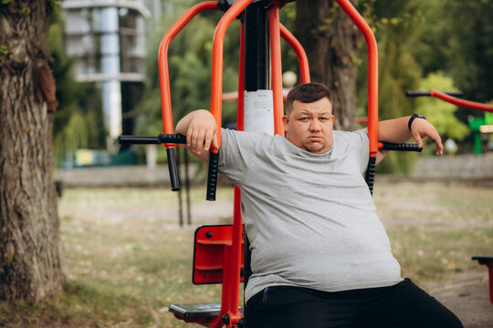 Fat man sitting on stairs after jogging, no faith in himself, insecurities