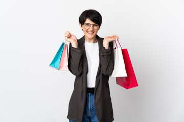 Woman with short hair isolated on white background holding shopping bags and smiling