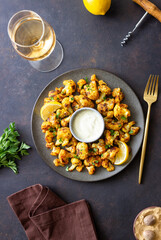 Fried cauliflower with lemon, herbs and white sauce. Healthy eating. Vegetarian food.