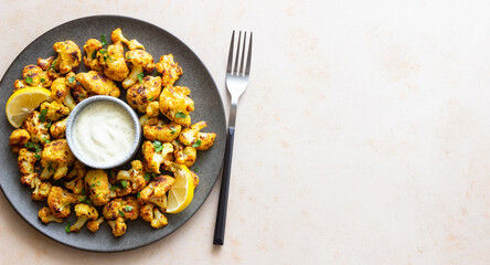 Fried cauliflower with lemon, herbs and white sauce. Healthy eating. Vegetarian food.