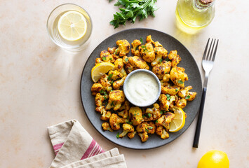 Fried cauliflower with lemon, herbs and white sauce. Healthy eating. Vegetarian food.