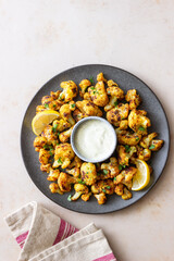 Fried cauliflower with lemon, herbs and white sauce. Healthy eating. Vegetarian food.